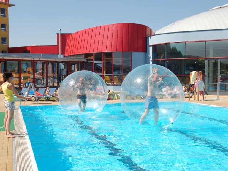 Wasserhüpfburg mieten, Wasserrutsche mieten, große Wasserbälle schwimmen auf einen Pool