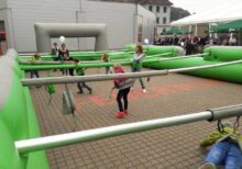 Jugendliche und Kinder spielen Menschenkicker
